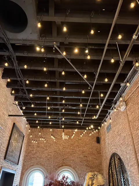 String lights across a brick-walled restaurant ceiling