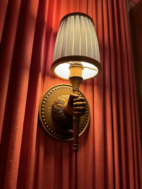Wall sconce against a red curtain